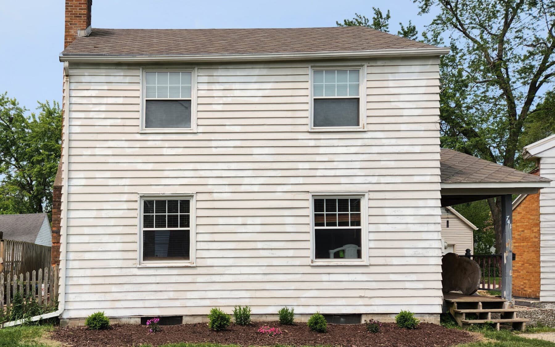 Two-story colonial home with faded white wood siding before exterior repaint by Fortoso Painting in Kalamazoo, Michigan