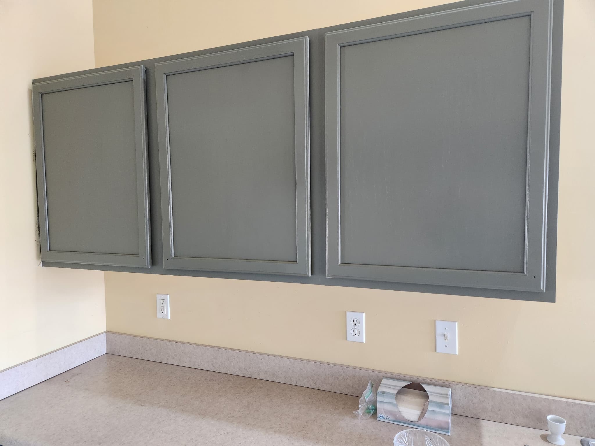 Same three cabinet doors refinished in a soft sage grey with a smooth factory-quality finish by Fortoso Painting in Vicksburg, Michigan